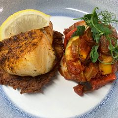 A picture of Harissa cod on a rosti served with ratatouille.