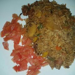 A picture of Fried rice garnished with tomatoes.