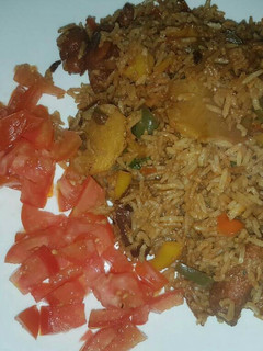 A picture of Fried rice garnished with tomatoes.