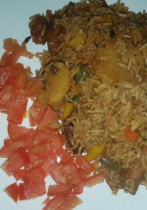 A picture of Fried rice garnished with tomatoes.