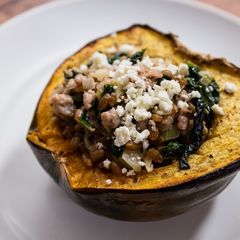 A picture of Roasted Acorn Squash with Sausage, Farro, Spinach, and Feta.