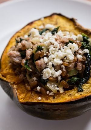 A picture of Roasted Acorn Squash with Sausage, Farro, Spinach, and Feta.