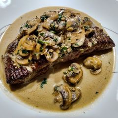 A picture of Steak with tarragon mushroom sauce.
