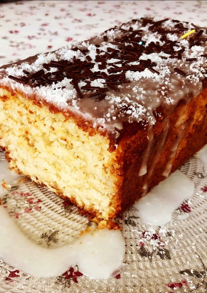 Una foto de Bizcocho de coco con glaseado de limón y topping de chocolate y coco 🥥 (sin huevo 🥚)