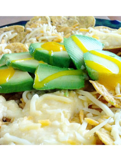 Una foto de Nachos con queso gratinado, aguacate y salsa de mango