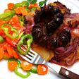 Chorizos sobre patatas y cebolla morada al horno
