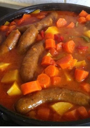 Une photo de Saucisses aux carottes pommes de terre carottes tomates et poivrons tricolores