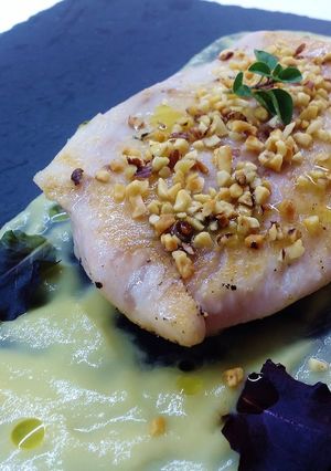 Foto di Filetto di pesce persico su crema di acciughe e porro, e granella di nocciole tostate