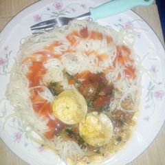 A picture of Spaghetti served with egg curry.