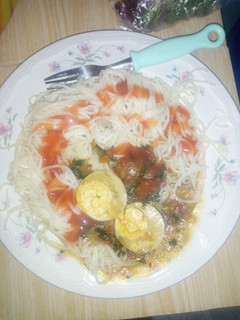 A picture of Spaghetti served with egg curry.