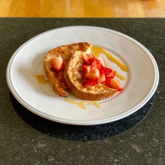 A picture of Eggy bread with strawberries and maple syrup.