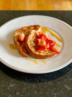 A picture of Eggy bread with strawberries and maple syrup.