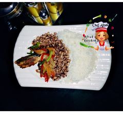 A picture of Rice and beans with veggies and fried fish.