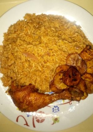 A picture of Jollof rice & ring plantain with peppered Chicken.
