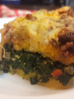 Una foto de Polenta rellena de espinaca con bolognesa