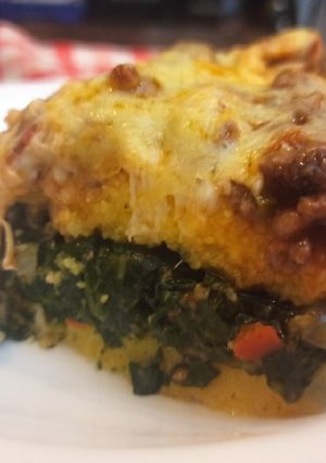 Una foto de Polenta rellena de espinaca con bolognesa
