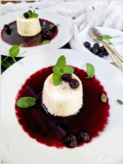 Una foto de Panna cotta con coulis de arándanos