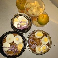 A picture of Jollof rice,boiled eggs and fruits.