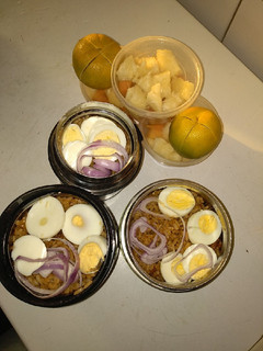 A picture of Jollof rice,boiled eggs and fruits.