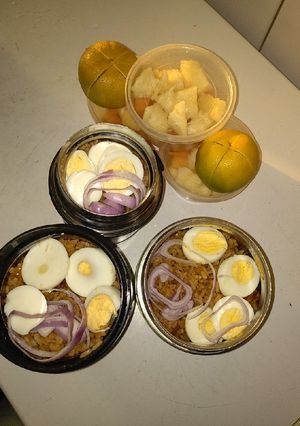 A picture of Jollof rice,boiled eggs and fruits.