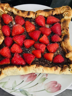 Una foto de Pizza de nocilla con fresas y plátano