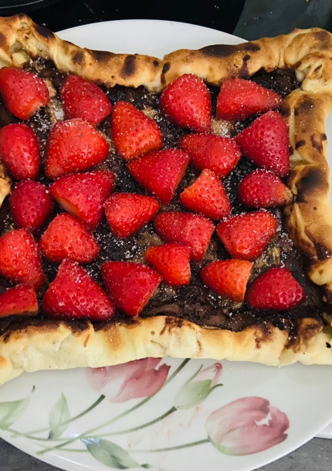 Una foto de Pizza de nocilla con fresas y plátano