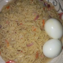 A picture of Indomie noodles with boiled eggs.