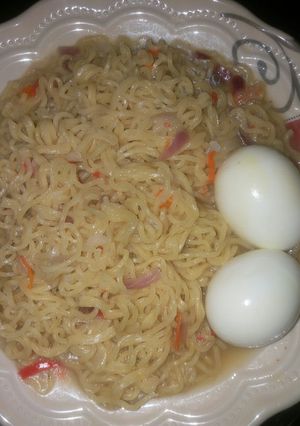 A picture of Indomie noodles with boiled eggs.
