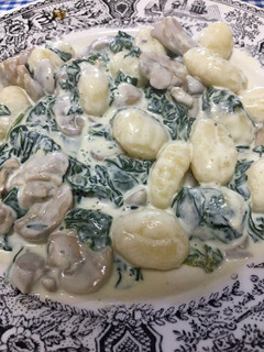 Una foto de Ñoquis con espinacas y champiñones