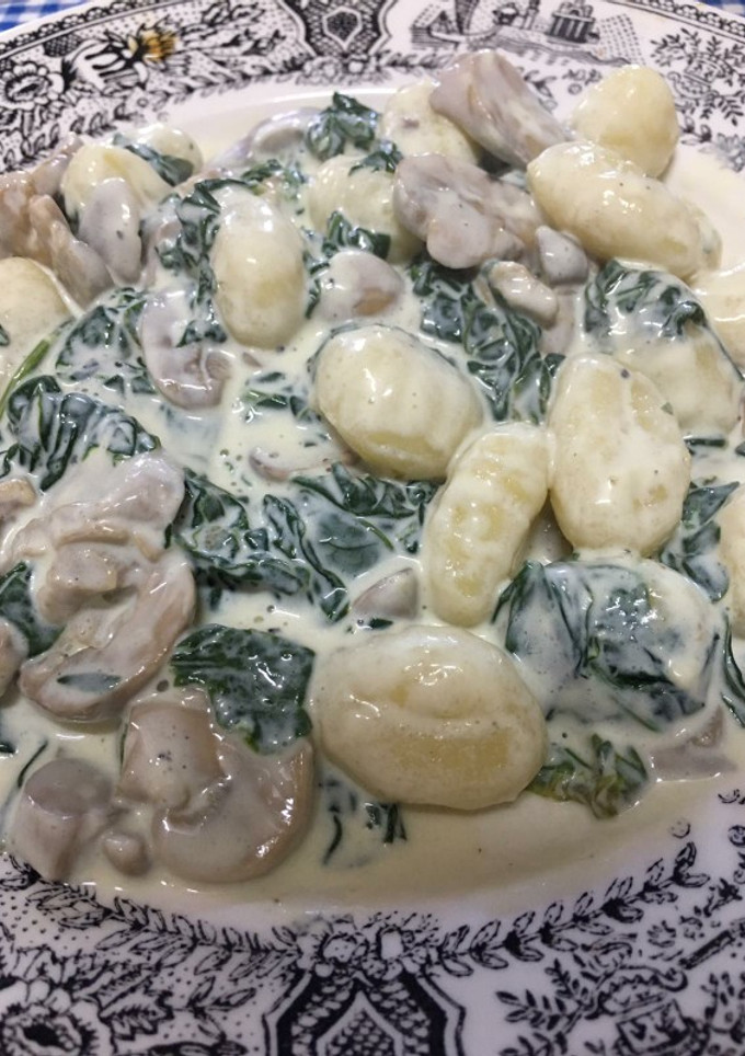 Una foto de Ñoquis con espinacas y champiñones