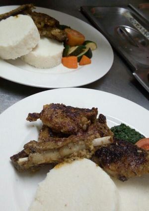 A picture of Chicken Kiev, ugali and fried spinach.