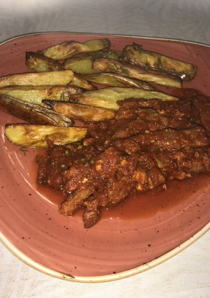 Una foto de Carne de asado especiada en salsa de tomates frescos