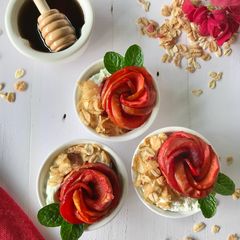 A picture of Poached apple roses in rhododendron juice with muesli and greek yoghurt.