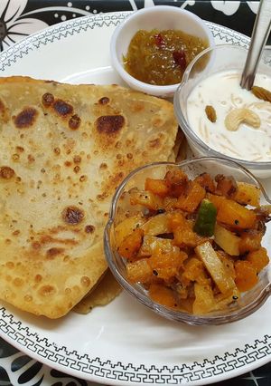 A picture of Paratha,Pumpkin Curry, Sweet Mango Pickle and Vermicelli Kheer.