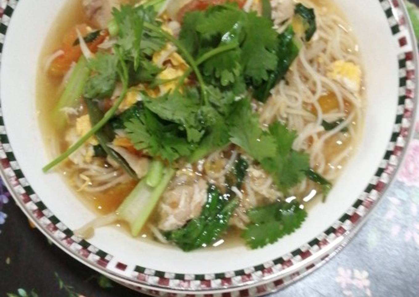 Sup mie ayam dengan tomat dan daun kemangi