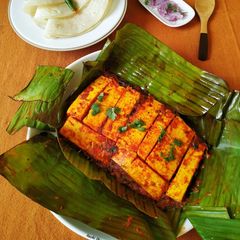 A picture of Paneer wrapped in banana leaf.