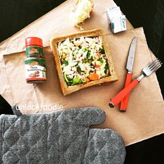 A picture of Square shaped Bread with veggies and Cheese.