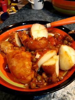 Una foto de Pollo arvejado acompañado de papas con cáscaras