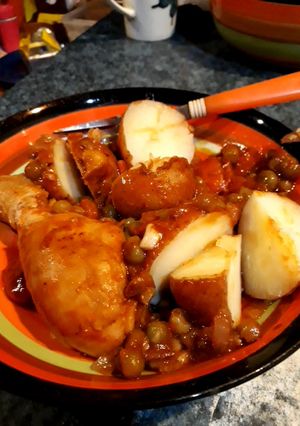 Una foto de Pollo arvejado acompañado de papas con cáscaras