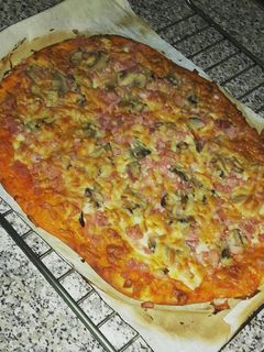 Una foto de Pizza de jamón york, bacon, champiñón y queso