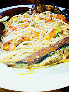 A picture of Veggie jollof spaghetti with fried fish.