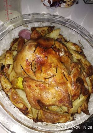 A picture of Roast chicken with potatoes,onion and garlic.