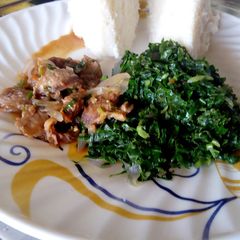 A picture of Beef stew, greens served with ugali.