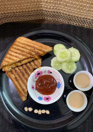 A picture of Chole bread sandwich with masala chai and cucumber.