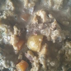 A picture of Rich beef stew with dumplings.