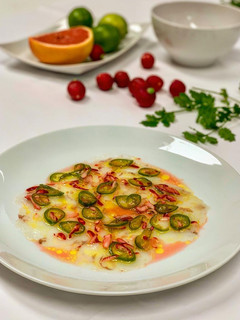 Una foto de Carpaccio de gambones con pomelo rosa, chiles y rábanos