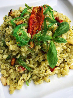 Una foto de Piñones de pasta al pesto con tomate seco y Wakame