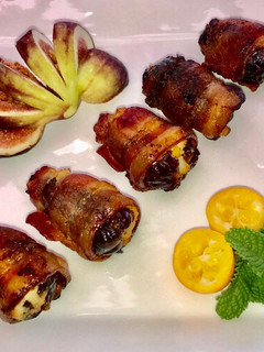 A picture of Bacon wrapped dates stuffed with ricotta cheese.