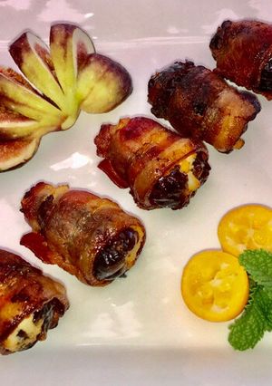 A picture of Bacon wrapped dates stuffed with ricotta cheese.