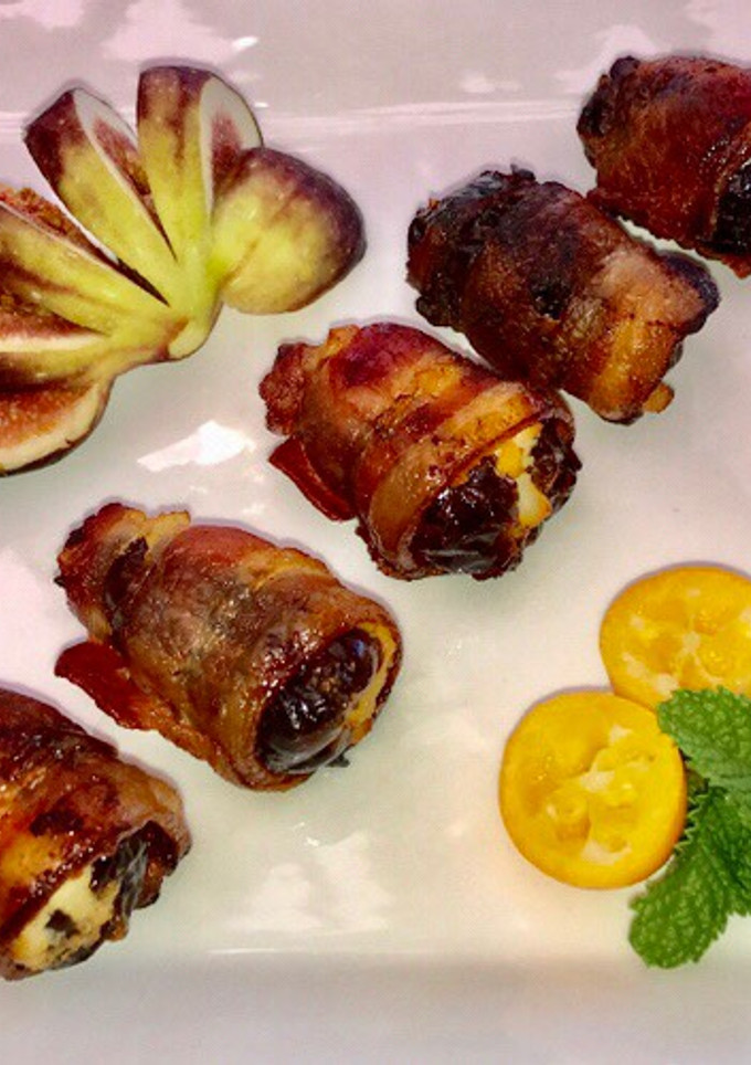 A picture of Bacon wrapped dates stuffed with ricotta cheese.